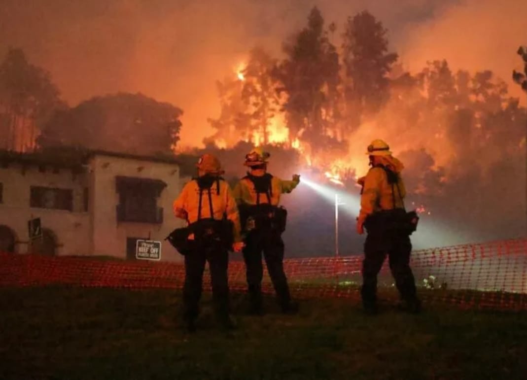 Petugas pemadam kebakaran bekerja saat asap dan api mengepul dari Sunset Fire di perbukitan yang menghadap ke kawasan Hollywood di Los Angeles, California, AS, 8 Januari 2025. REUTERS/David Swanson.