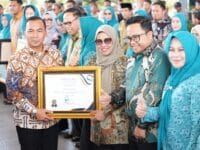 PENGHARGAAN. Bupati Gowa, Sitti Husniah Talenrang dan Wakil Bupati Gowa, Darmawangsyah Muin saat menerima penghargaan dari Menteri Kependudukan dan Pembangunan Keluarga/BKKBN, Wihaji, pada Peringatan Hari Keluarga Nasional (HARGANAS) Ke-32 di Lapangan Karebosi, Makassar, Minggu (27/7).