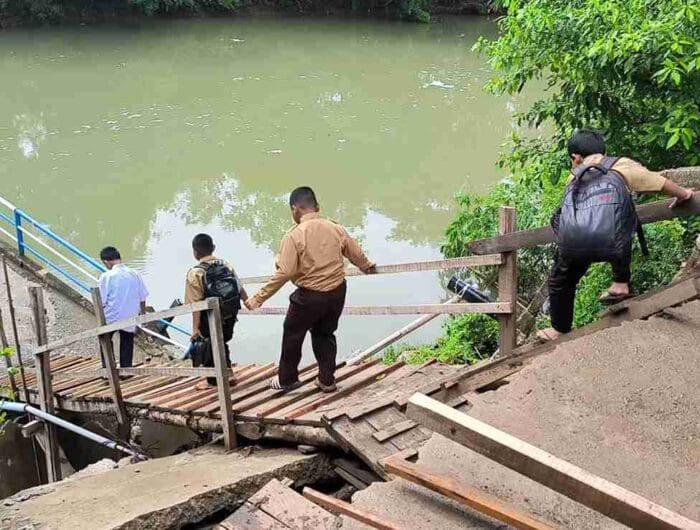 BAHAYA. Pelajar di Desa Bonto Tallasa, Maros tetap melalui jembatan yang ambruk di desa itu.