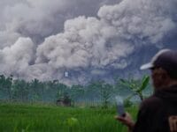 ERUPSI. Warga memantau erupsi yang terjadi di Gunung Semeru.