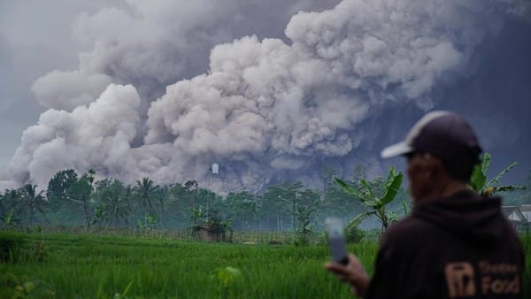 ERUPSI. Warga memantau erupsi yang terjadi di Gunung Semeru.