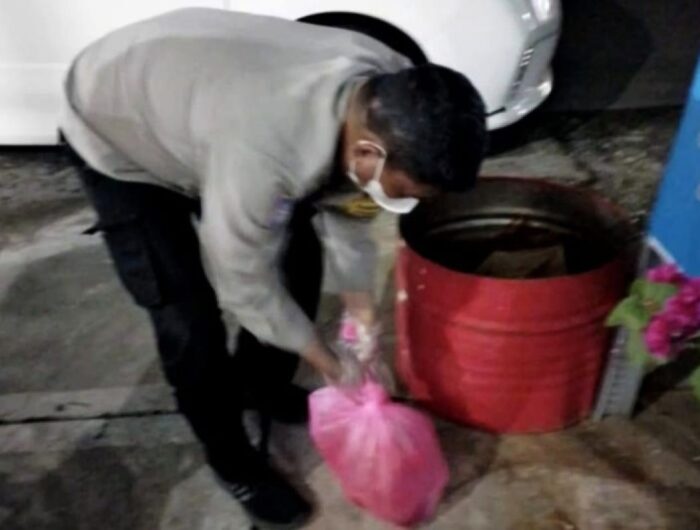 TEROR. Polisi membuka bungkusan berisi kepala kambing busuk yang menjadi teror yang dikirim orang yang tidak dikenal di sebuah rumah makan di Makassar.