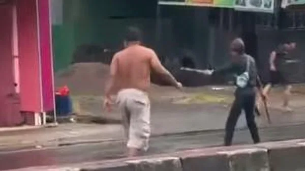 TEROR. Iccang (25) menebar ancaman warga yang melinmtas di jalan itu dengan parang dan busur.